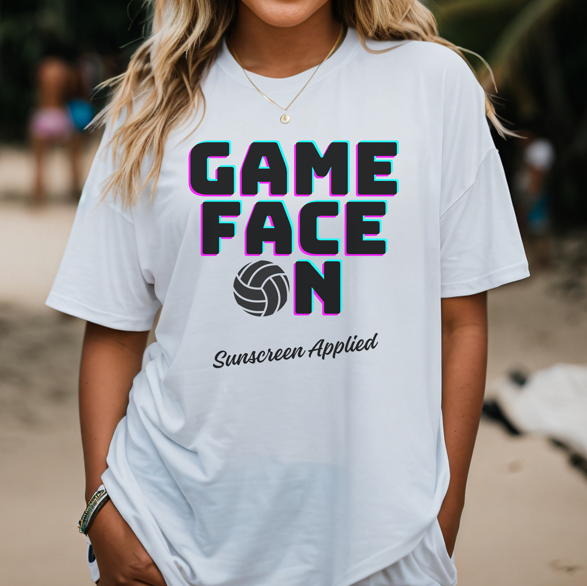 Person wearing a white t-shirt with 'GAME FACE ON Sunscreen Applied' text and volleyball graphic.